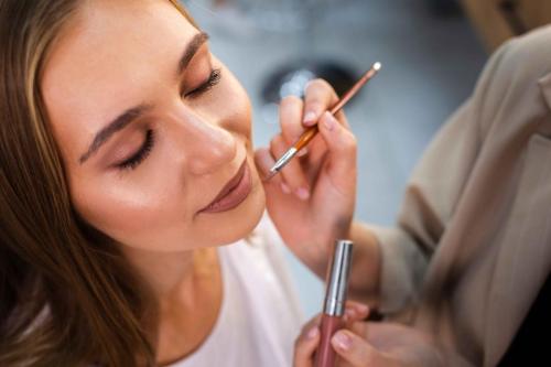 close-up-make-up-artist-applying-nude-lipstick-woman-with-brush_11zon